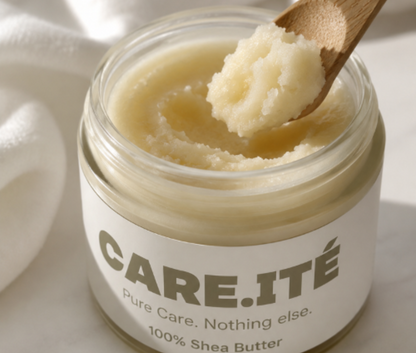 Close-up of Care.ité 100% Pure Shea Butter in a glass jar, with a bamboo spoon scooping the natural shea butter texture. Natural skincare product photographed in soft sunlight with a clean white background.